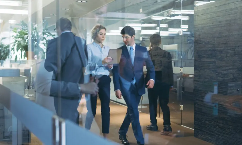 Business professionals walking through modern office corridor